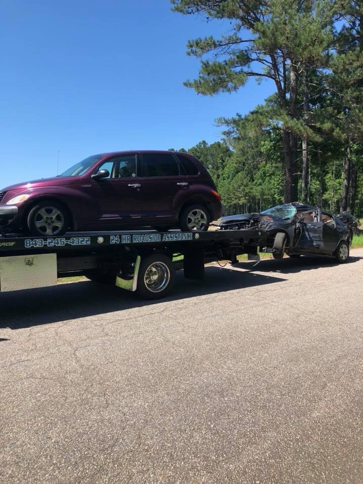 Our flatbed carrying one vehicle with a second damaged car loaded behind it